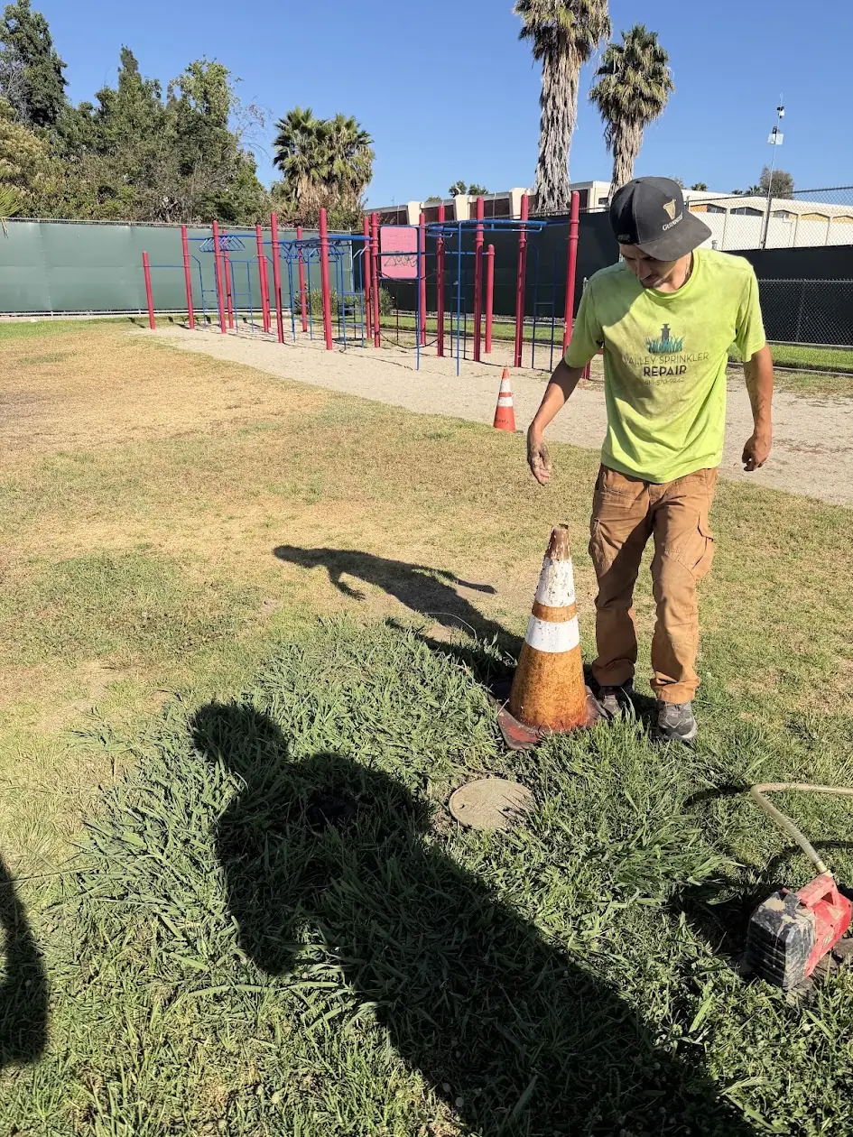 Technician maintaining the sprinkler system on a church playfield