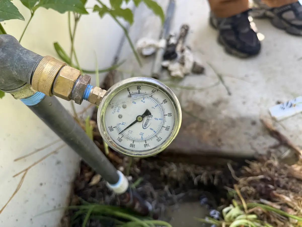 Pressure gauge on a hose bib showing high water pressure at a home