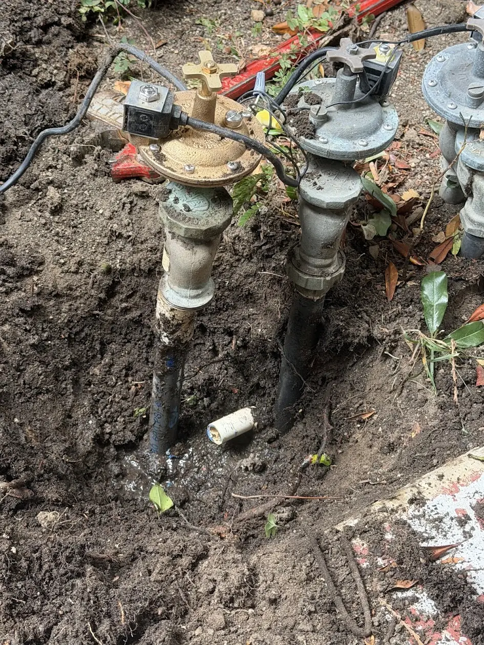 Leaking anti-siphon sprinkler valve manifold exposed for repair