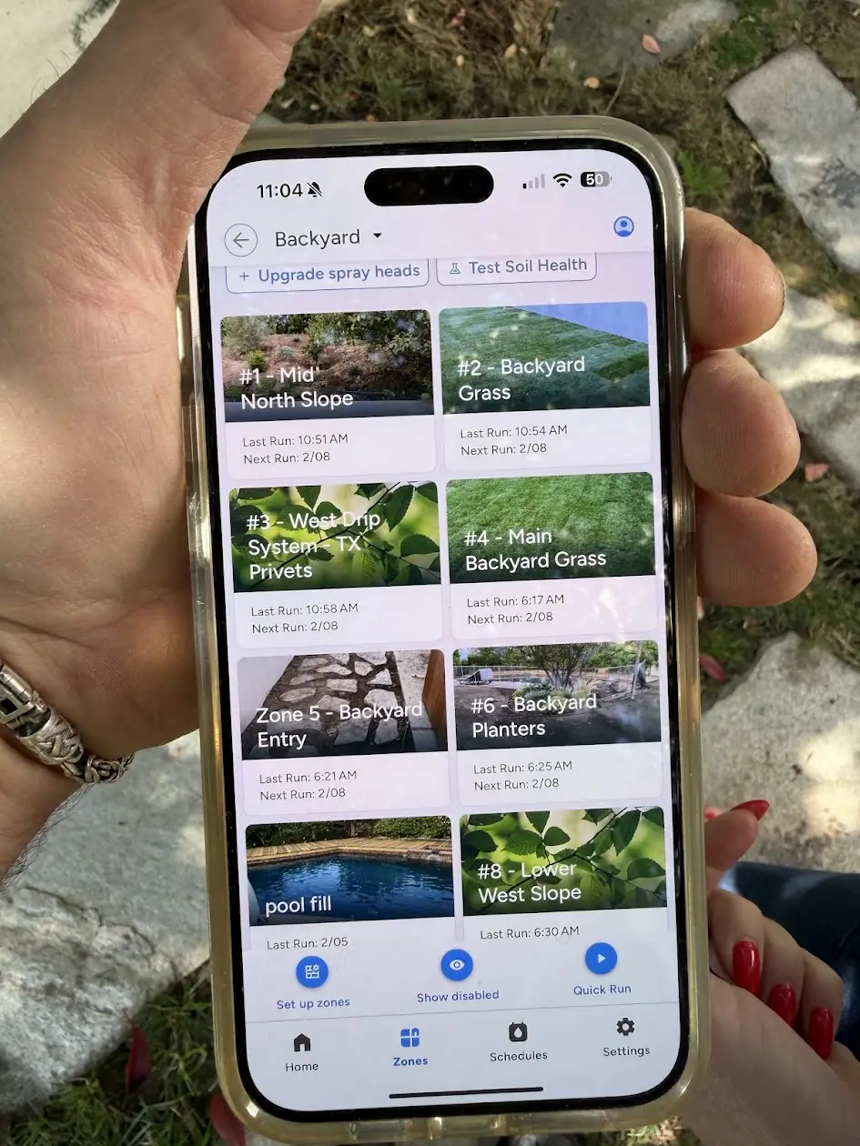 Smart sprinkler controller app on a phone showing each watering zone